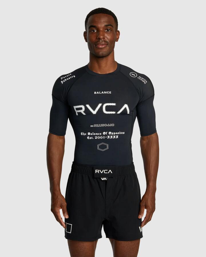Image of a model wearing Tops. Productname: RVCA - Mens Sport Short Sleeve Rash Vest - Black All Brand 2 - in Black All Brand 2 colour by brand - RVCA
