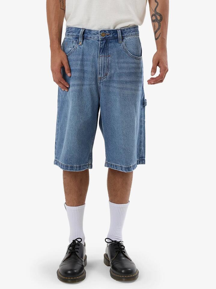 Image of a model wearing Shorts. Product name - Thrills Mens Big Slacker Denim Shorts Dark Dust Blue in Dark Dust Blue colour by brand - Thrills