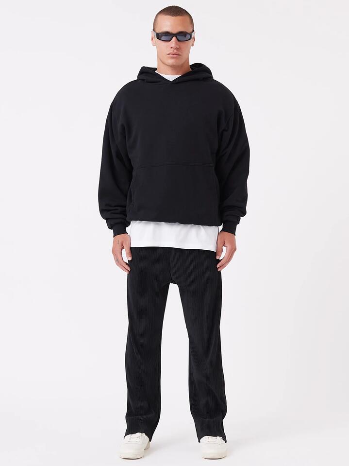 Image of a model wearing Pants. Productname: Zanerobe Pleated Pant in Black colour by brand - Zanerobe