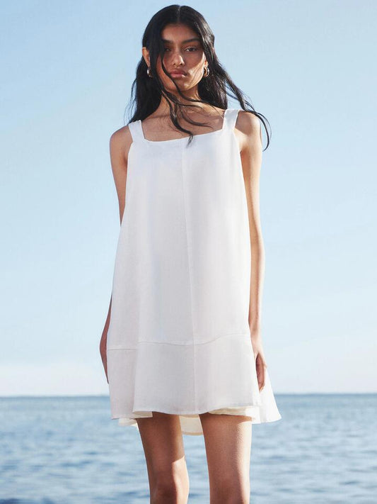 Image of a model wearing Dress. Productname: Lulu & Rose Lee Bow Mini Dress in Off White colour by brand - Lulu & Rose