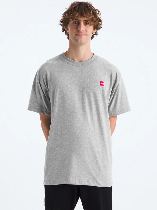 Image of a model wearing Shorts. Productname: The North Face Short-Sleeve Heavyweight Relaxed Tee in Light Grey Heather/Summits colour by brand - The North Face