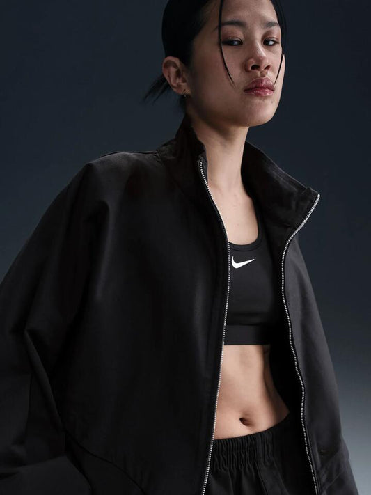 Image of a model wearing Outerwear. Productname: Nike Women's Windrunner Twill Jacket in Black/Black/Velvet Brown colour by brand - Nike