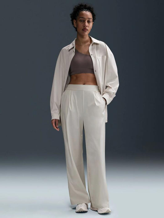 Image of a model wearing Pants. Productname: Nike Women's Dri-Fit High-Waisted Loose Wide-Leg Pants in Lt Orewood Brn/Lt Iron Ore colour by brand - Nike