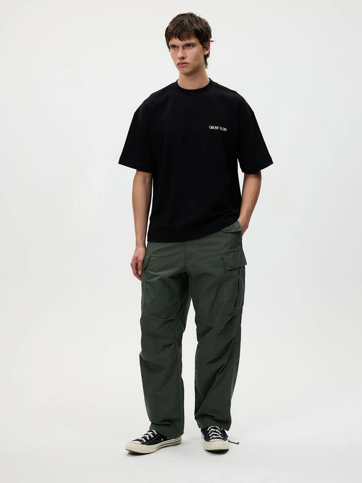 Image of a model wearing Tops. Productname: Article One Vine Tee in Washed Black colour by brand - Article One