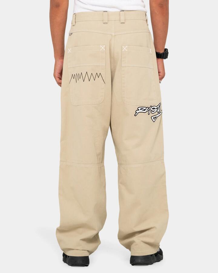 Image of a model wearing Pants. Product name - Rusty Mens Step-Stone Baggy Pants Abbey Stone Solid in Abbey Stone - Solid colour by brand - Rusty