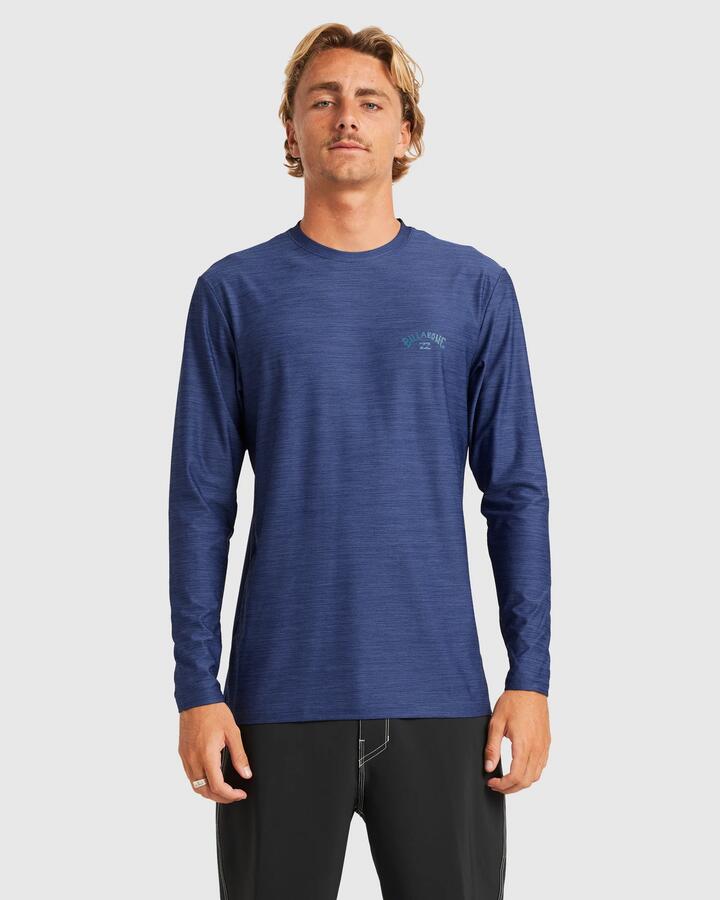 Image of a model wearing Tops. Product name - Billabong Mens Shoreline Loose Fit Long Sleeve Rash Vest Denim Heather in Denim Heather colour by brand - Billabong