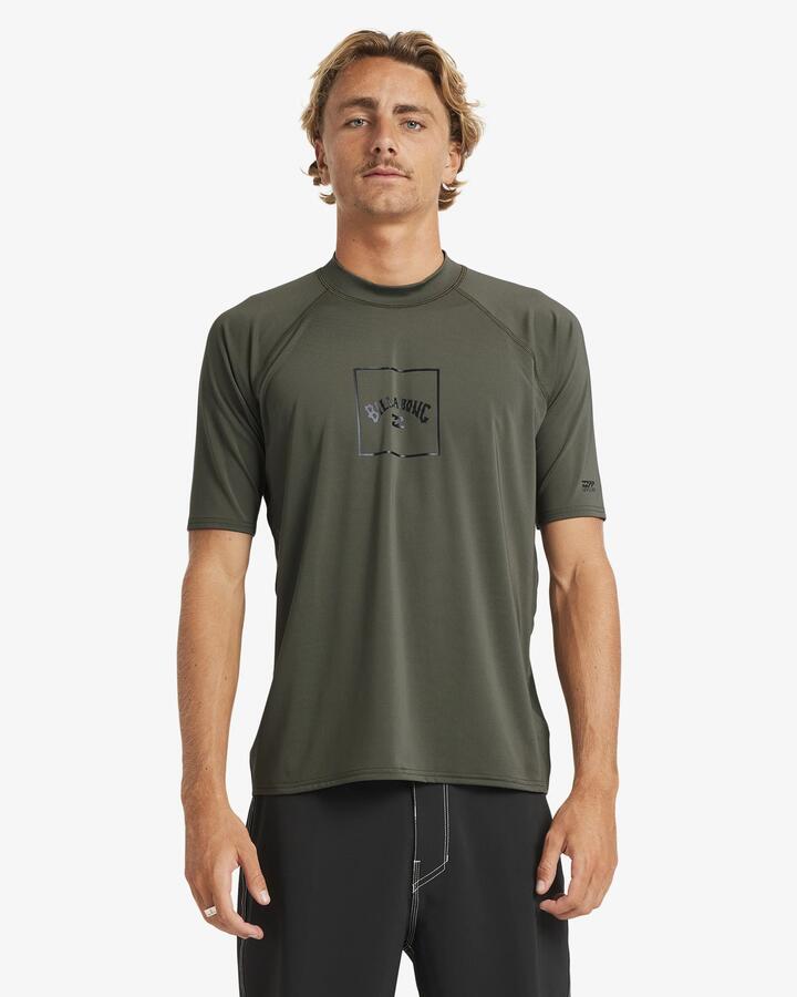 Image of a model wearing Tops. Product name - Billabong Mens Boxed Arch Short Sleeve Rash Vest Military in Military colour by brand - Billabong