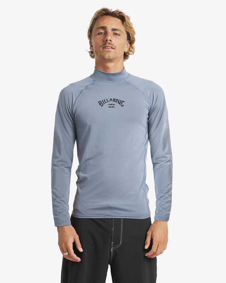 Image of a model wearing Tops. Product name - Billabong Mens All Day Arch Long Sleeve Rash Vest Steel Blue in Steel Blue colour by brand - Billabong