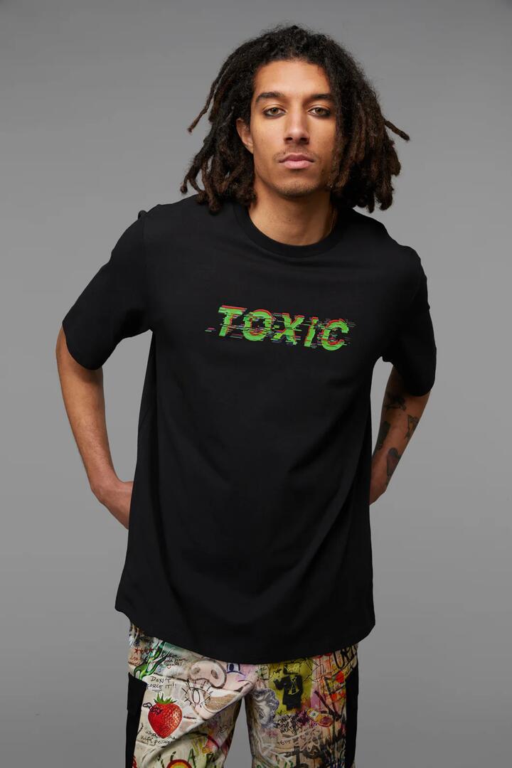 Image of a model wearing Tops. Productname: Toxic Tee in Black/Green colour by brand - Black Friday
