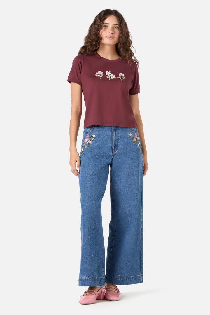 Image of a model wearing Tops. Productname: Yvette Butterfly Flower Tee in Plum colour by brand - Princess Highway