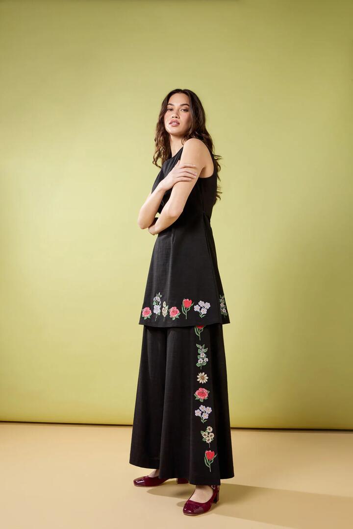 Image of a model wearing Pants. Productname: Fleur Embroidered Pant in Black colour by brand - Princess Highway