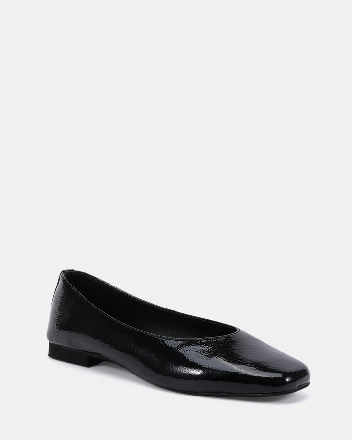 Image of a model wearing Skirts. Product name - Chester Black Crinkle Patent Smart Casual in Black Crinkle Patent colour by brand - Novo