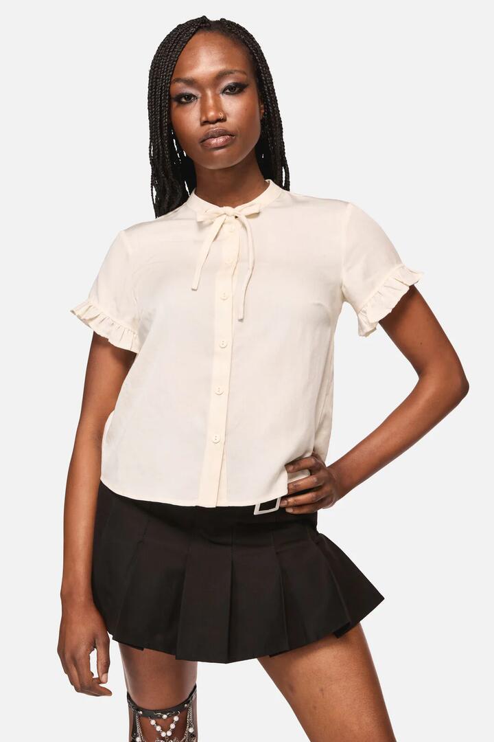 Image of a model wearing Tops. Productname: Crypt Bow SS Blouse in Cream colour by brand - Black Friday