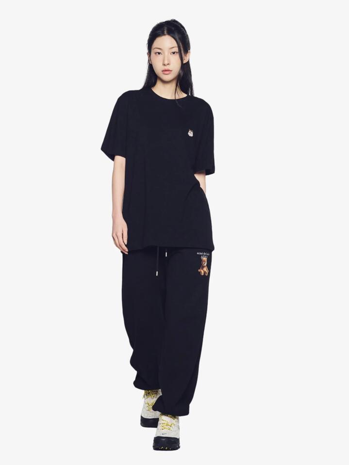 Image of a model wearing Tops. Productname: ADLV Ac Bear Wappen T-Shirt in Black colour by brand - ADLV