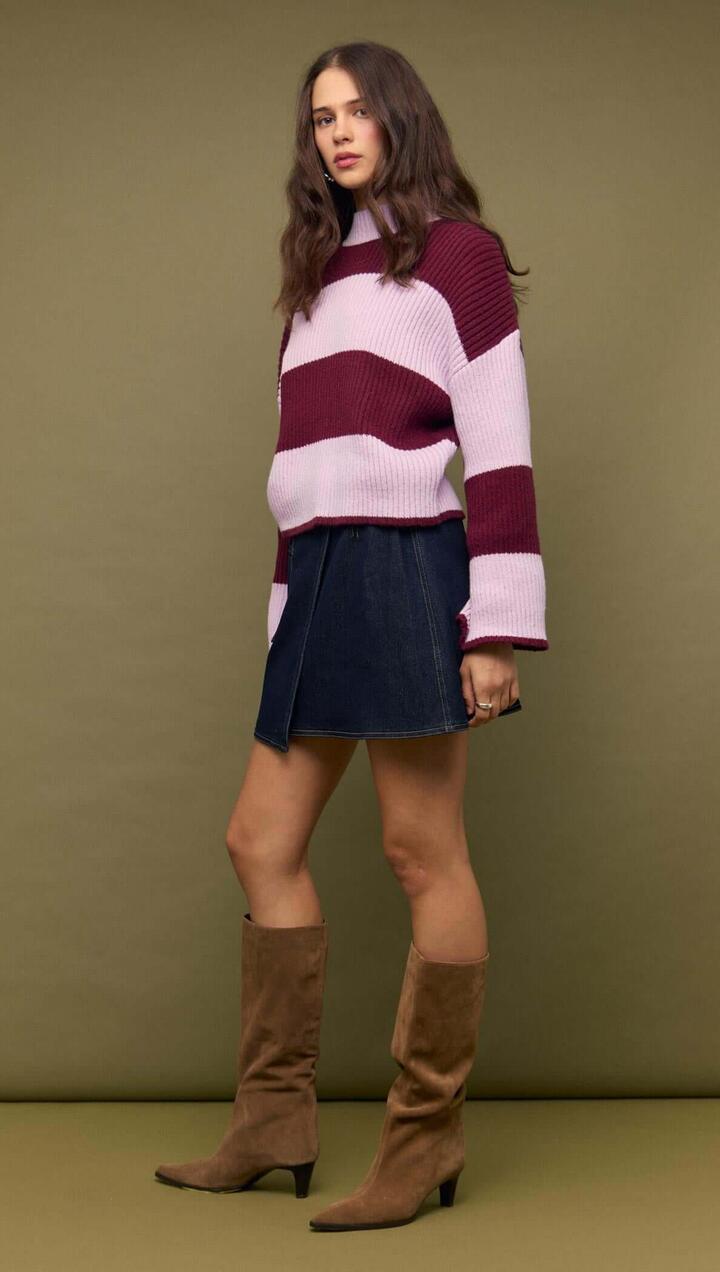 Image of a model wearing Skirts. Product name - Denim Mini Wrap Skirt With Buckle Detail in Indigo Wash colour by brand - MINKPINK