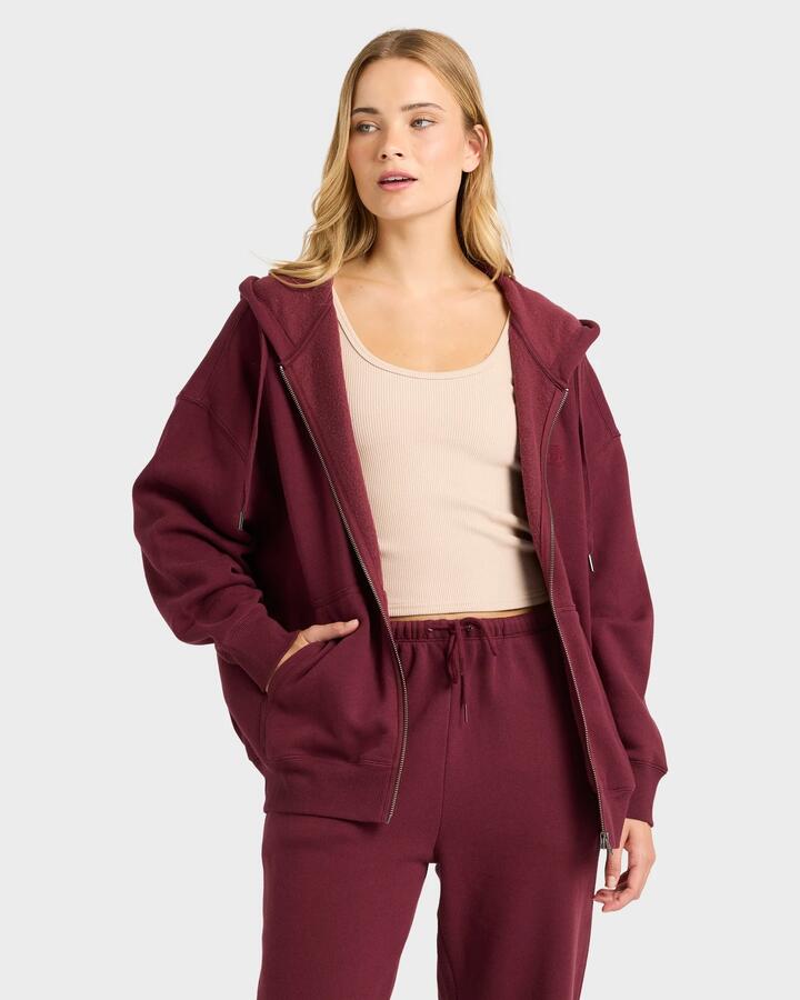 Image of a model wearing Outerwear. Productname: billabong - Womens Wave Essentials Zip Pullover Hoodie - Red Dahlia - in Red Dahlia colour by brand - billabong
