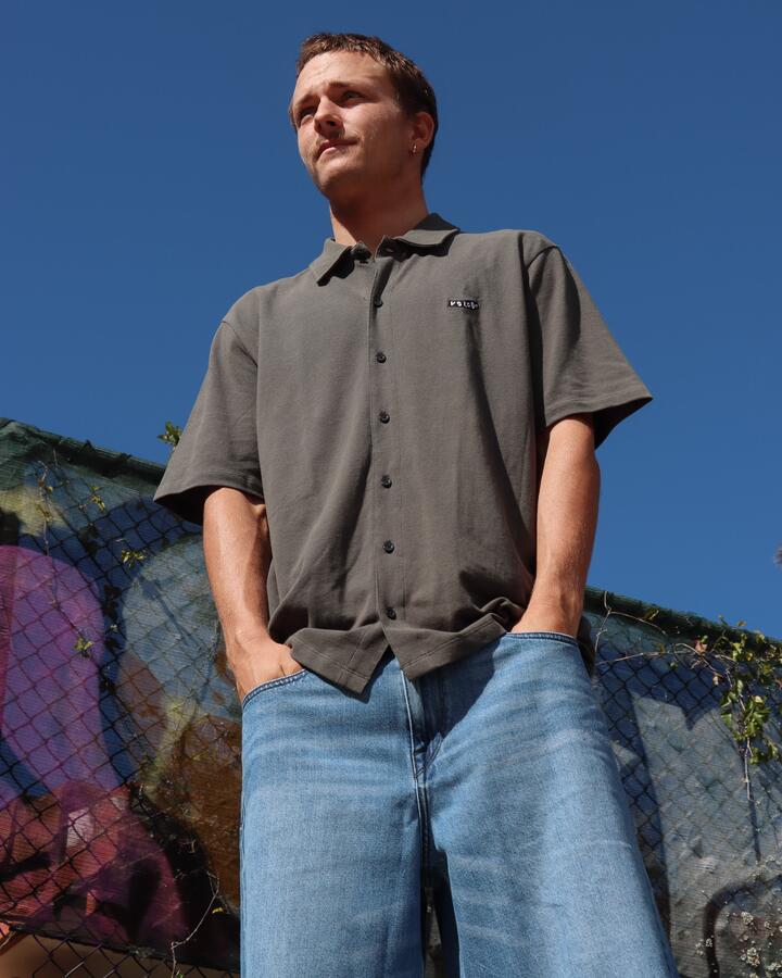 Image of a model wearing Tops. Product name - Volcom Mens Chavo Button Short Sleeve Shirt Castlerock in Castlerock colour by brand - Volcom
