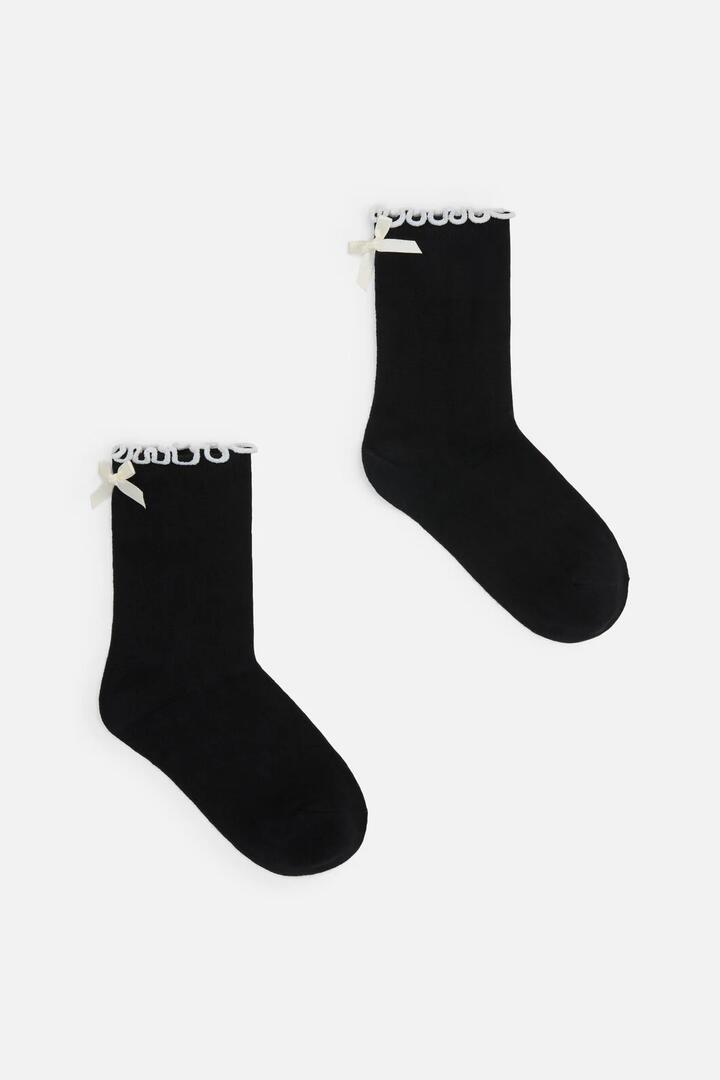 Image of a model wearing Shorts. Productname: Bow Back Short Sock in Black colour by brand - Dangerfield