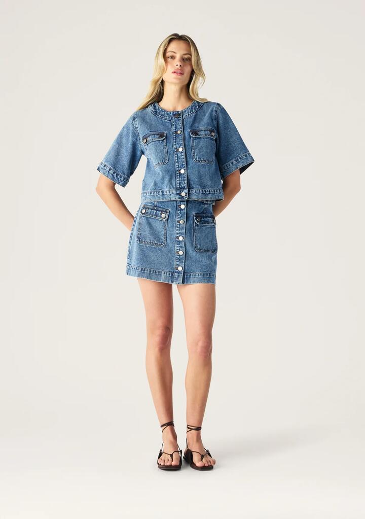 Image of a model wearing Skirts. Productname: Aveline Denim Mini Skirt | MOS The Label in Light Indigo colour by brand - MOS The Label