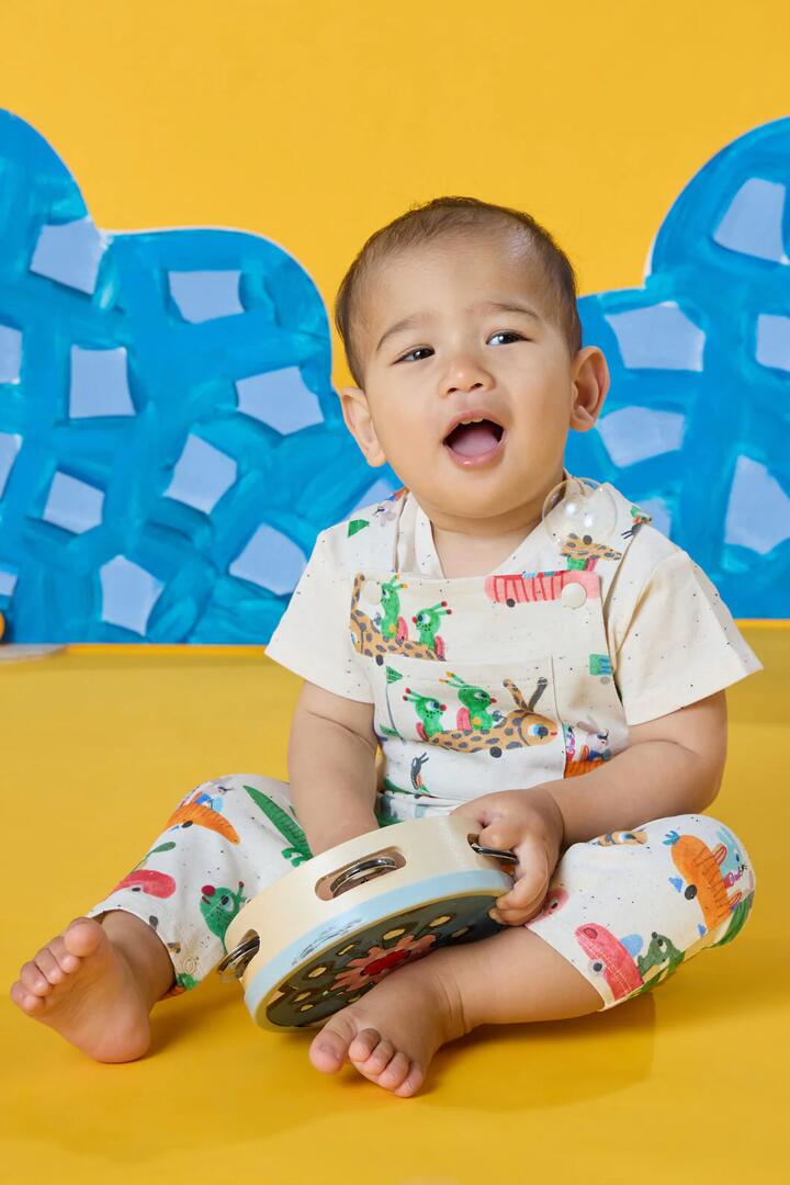 Image of a model wearing Pants. Product name - Speedy Bug Baby Overalls in Cream colour by brand - Gorman