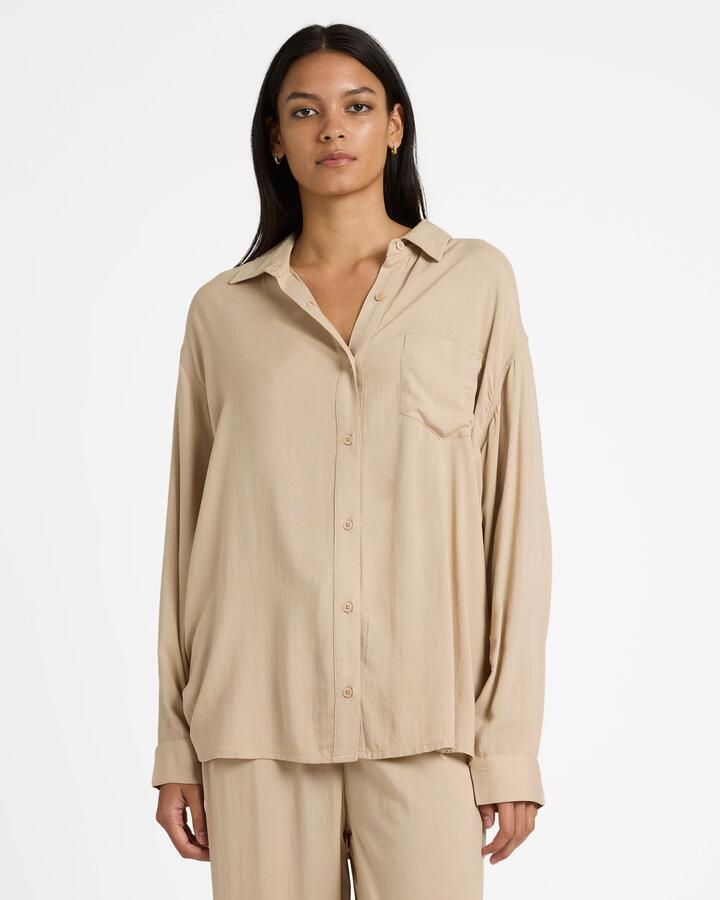 Image of a model wearing Tops. Productname: RVCA Womens Showdown Long Sleeve Shirt Oxford Tan - in Oxford Tan colour by brand - RVCA