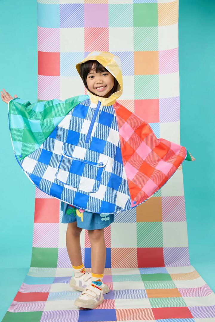 Image of a model wearing Rain Coats. Product name - Gingham Splice Kids Poncho in Multi colour by brand - Gorman