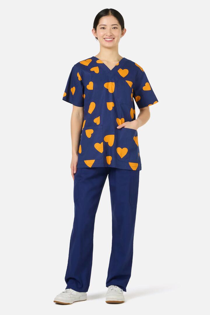 Image of a model wearing Uniforms & Workwear. Productname: Orange Hearts Top & Pant Scrub Set in Navy colour by brand - Scrubs With Love