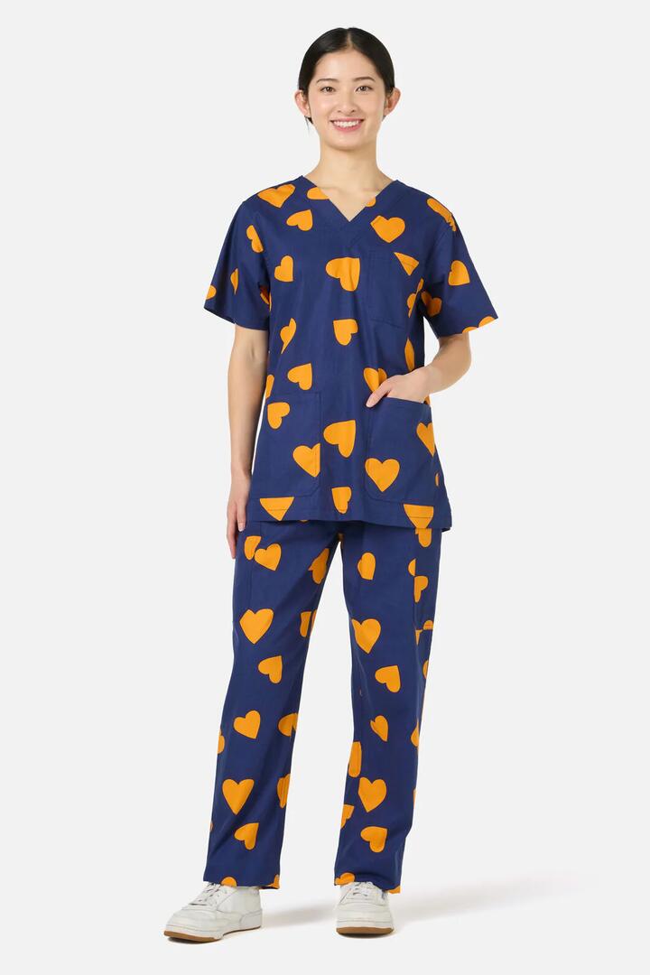 Image of a model wearing Uniforms & Workwear. Productname: Orange Hearts Scrub Set in Navy colour by brand - Scrubs With Love