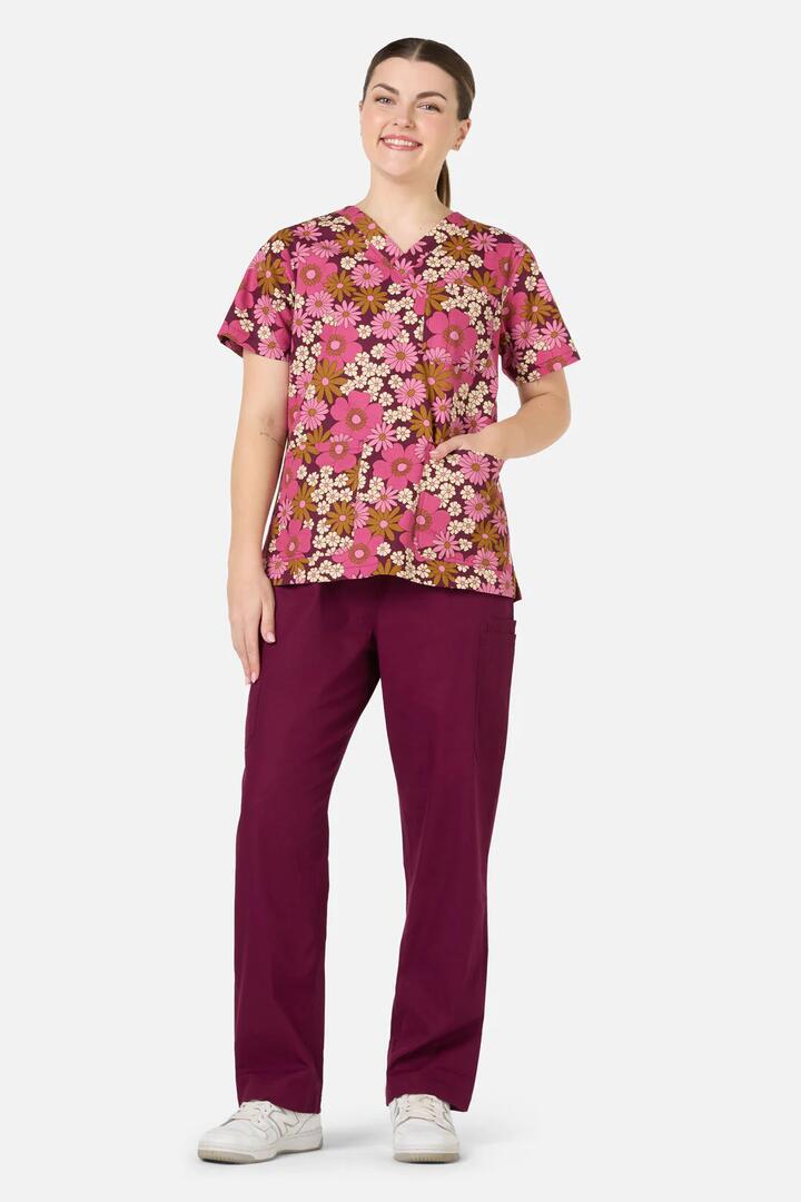 Image of a model wearing Uniforms & Workwear. Productname: Brigette Top & Pant Scrub Set in Pink colour by brand - Scrubs With Love