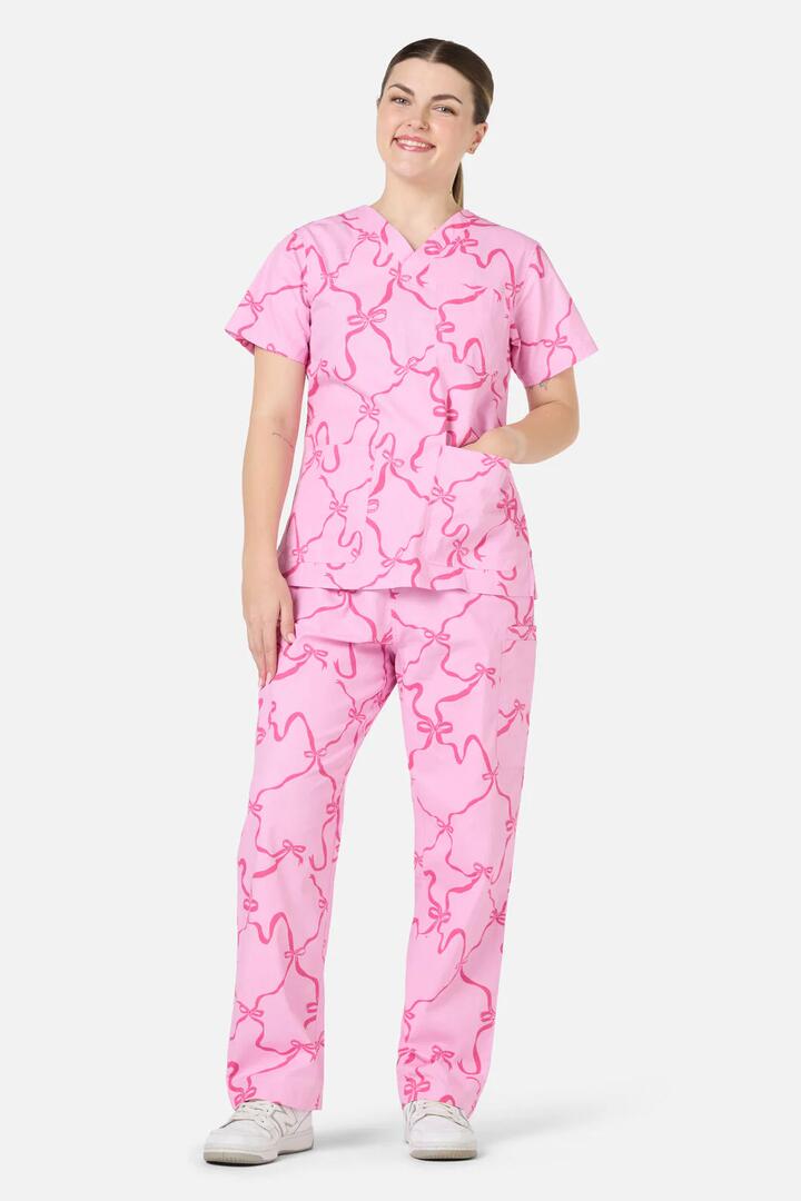 Image of a model wearing Uniforms & Workwear. Productname: Pink Bows Scrub Set in Pink colour by brand - Scrubs With Love