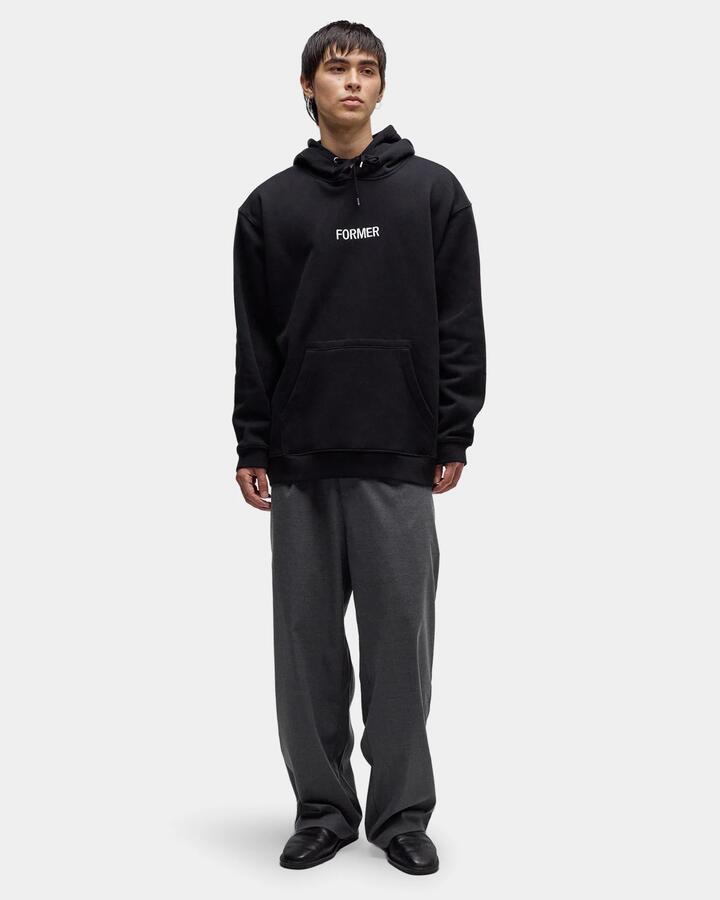 Image of a model wearing Outerwear. Product name - Former Mens Legacy Embroidery Pullover Hoodie Black in Black colour by brand - Former