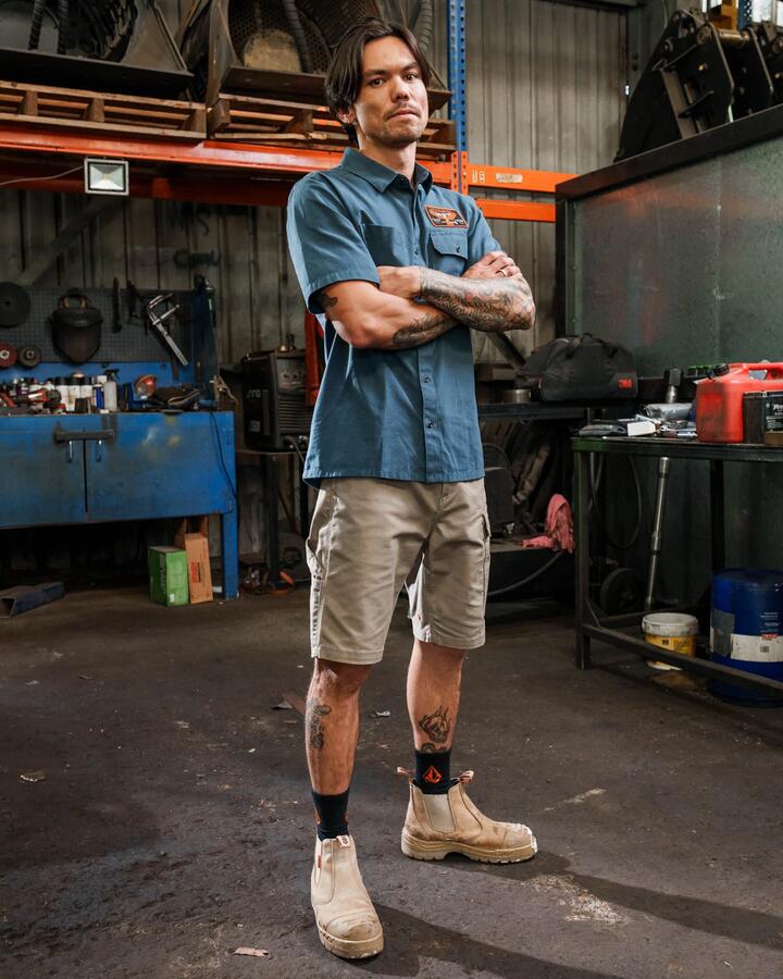 Image of a model wearing Tops. Product name - Volcom Mens Workwear Slab City Short Sleeve Shirt Midnight Blue in Midnight Blue colour by brand - Volcom