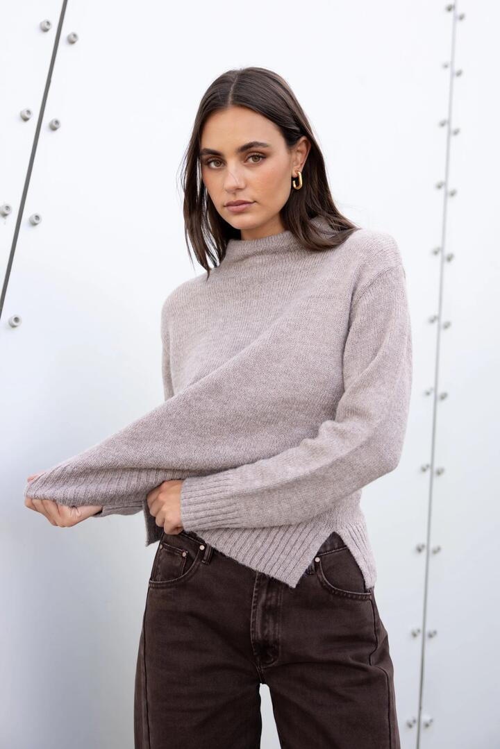 Image of a model wearing Outerwear. Product name - Huddle Mushroom High Neck Knit Jumper in Mushroom colour by brand - By Rosa.