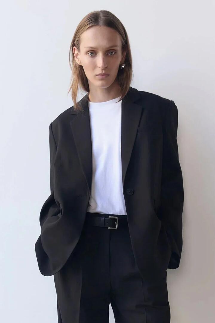 Image of a model wearing Outerwear. Product name - Orla Black Relaxed Blazer in Black colour by brand - Nude Lucy
