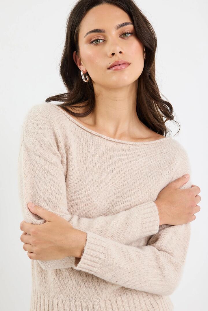 Image of a model wearing Outerwear. Product name - Society Oat Off Shoulder Jumper in Oat colour by brand - By Rosa.