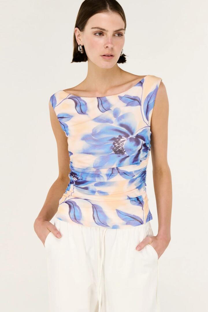 Image of a model wearing Tops. Product name - Fleur Blue Blurred Floral Sleeveless Mesh Top in Blue colour by brand - Staple The Label