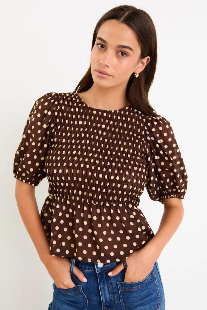Image of a model wearing Tops. Product name - Requite Chocolate Polka Dot Shirred Body SS Top in Chocolate Polka Dot colour by brand - Among the Brave