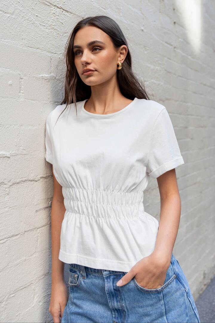 Image of a model wearing Tops. Product name - Svelte Ivory Shirred Detail SS Tee in Ivory colour by brand - Among the Brave