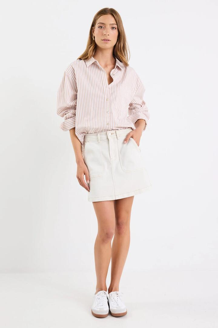 Image of a model wearing Skirts. Product name - Orchard Ecru Denim Pocket Front Mini Skirt in Ecru colour by brand - Ivy + Jack