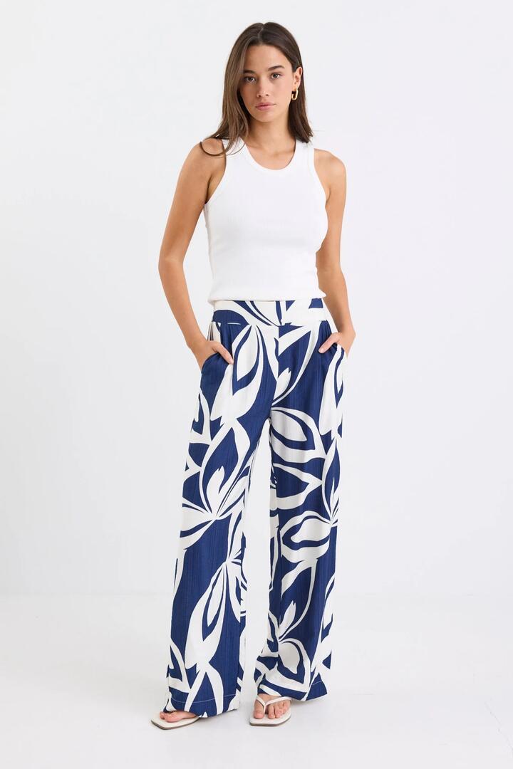 Image of a model wearing Pants. Product name - Metropolitan Navy Cutout Print Wide Leg Pants in Navy Cutout Print colour by brand - Stories be Told