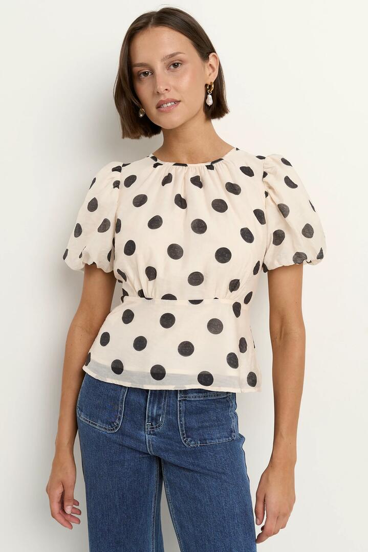 Image of a model wearing Tops. Product name - Finali Cream Black Polka Dot Puff Short Sleeve Top in Cream Black Polka Dot colour by brand - Stories be Told