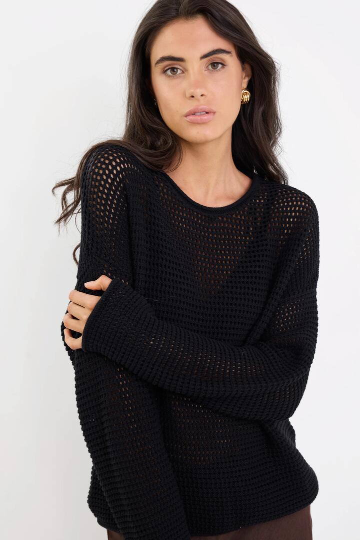Image of a model wearing Outerwear. Product name - Dawn Black Crochet Knit Jumper in Black colour by brand - RE:UNION Label