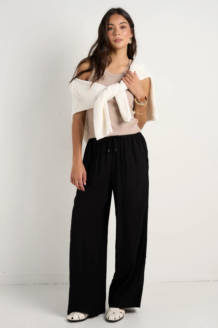 Image of a model wearing Pants. Product name - Townie Onyx Velvet Stripe Side Wide Leg Pants in Onyx colour by brand - Stories be Told