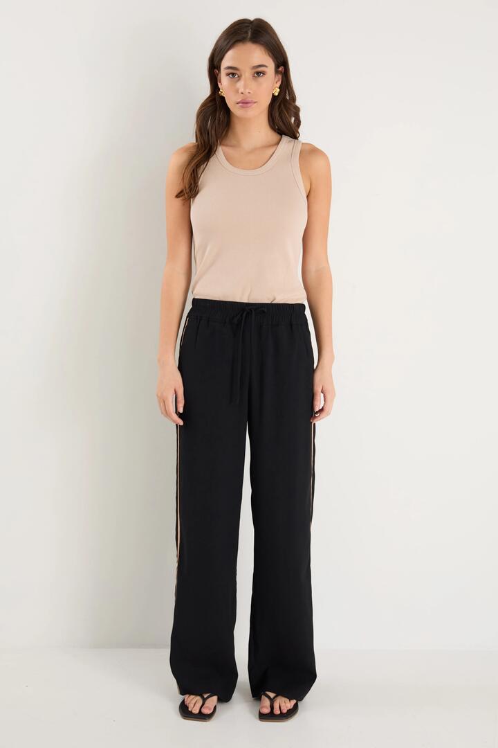 Image of a model wearing Pants. Product name - Confidant Black Crepe Camel Side Stripe Wide Pants in Black colour by brand - Among the Brave