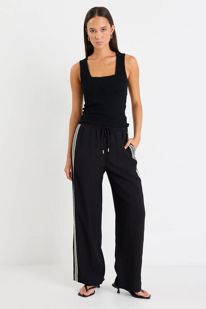 Image of a model wearing Pants. Product name - Vibe Black Jacquard Stripe Wide Leg Pants in Black Jaquard Stripe colour by brand - Stories be Told