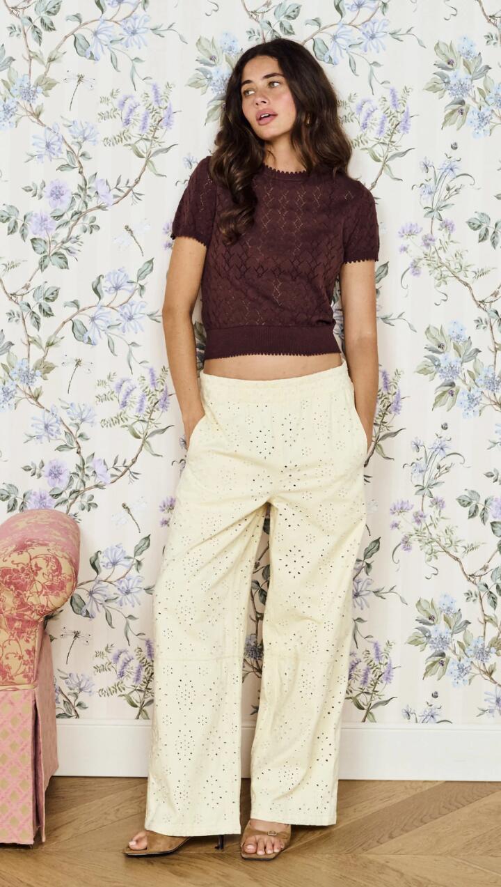 Image of a model wearing Pants. Product name - Relaxed Fit Cotton Denim Broderie Pant in Cream colour by brand - MINKPINK