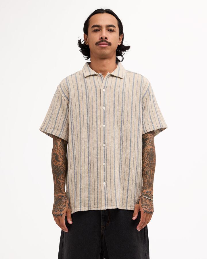 Image of a model wearing Tops. Product name - Rvca Mens Vacancy Stripe Short Sleeve Shirt Light Khaki in Light Khaki colour by brand - Rvca