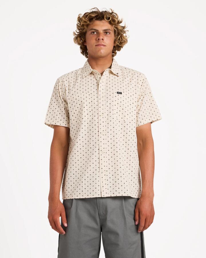 Image of a model wearing Tops. Product name - Rvca Mens Breezy Short Sleeve Shirt Ceramic in Ceramic colour by brand - Rvca