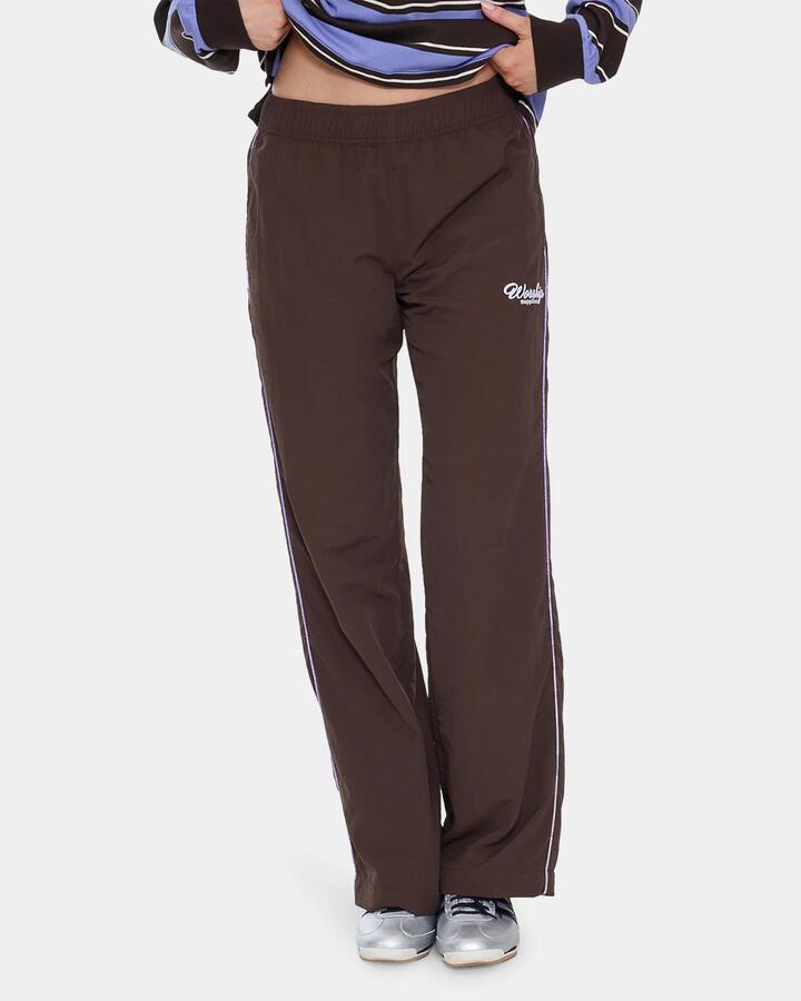 Image of a model wearing Pants. Product name - Worship Womens Coed Nylon Track Pants Ganache in Ganache colour by brand - Worship