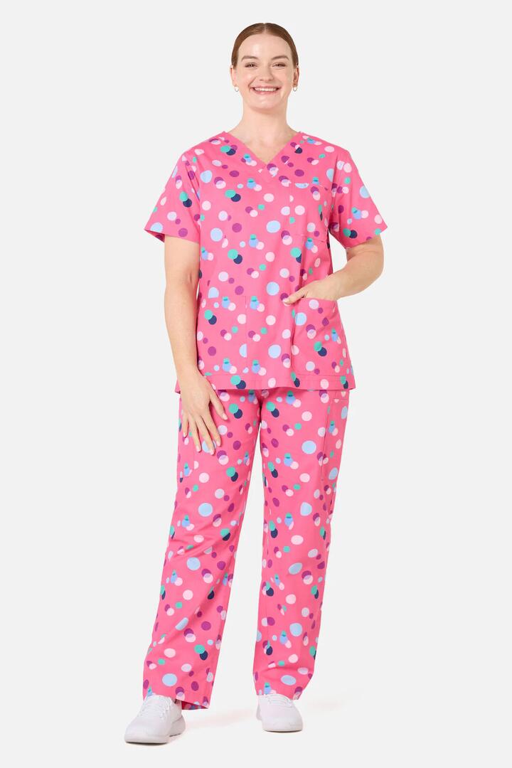 Image of a model wearing Uniforms & Workwear. Product name - Polka Dots Scrub Set in Pink colour by brand - Scrubs With Love
